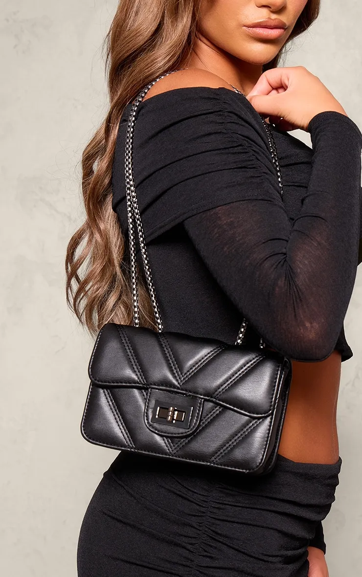 Quilted black shoulder bag with chain handle.