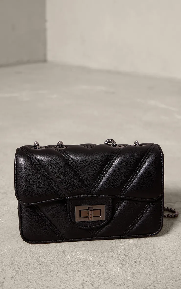 Quilted black shoulder bag with chain handle.