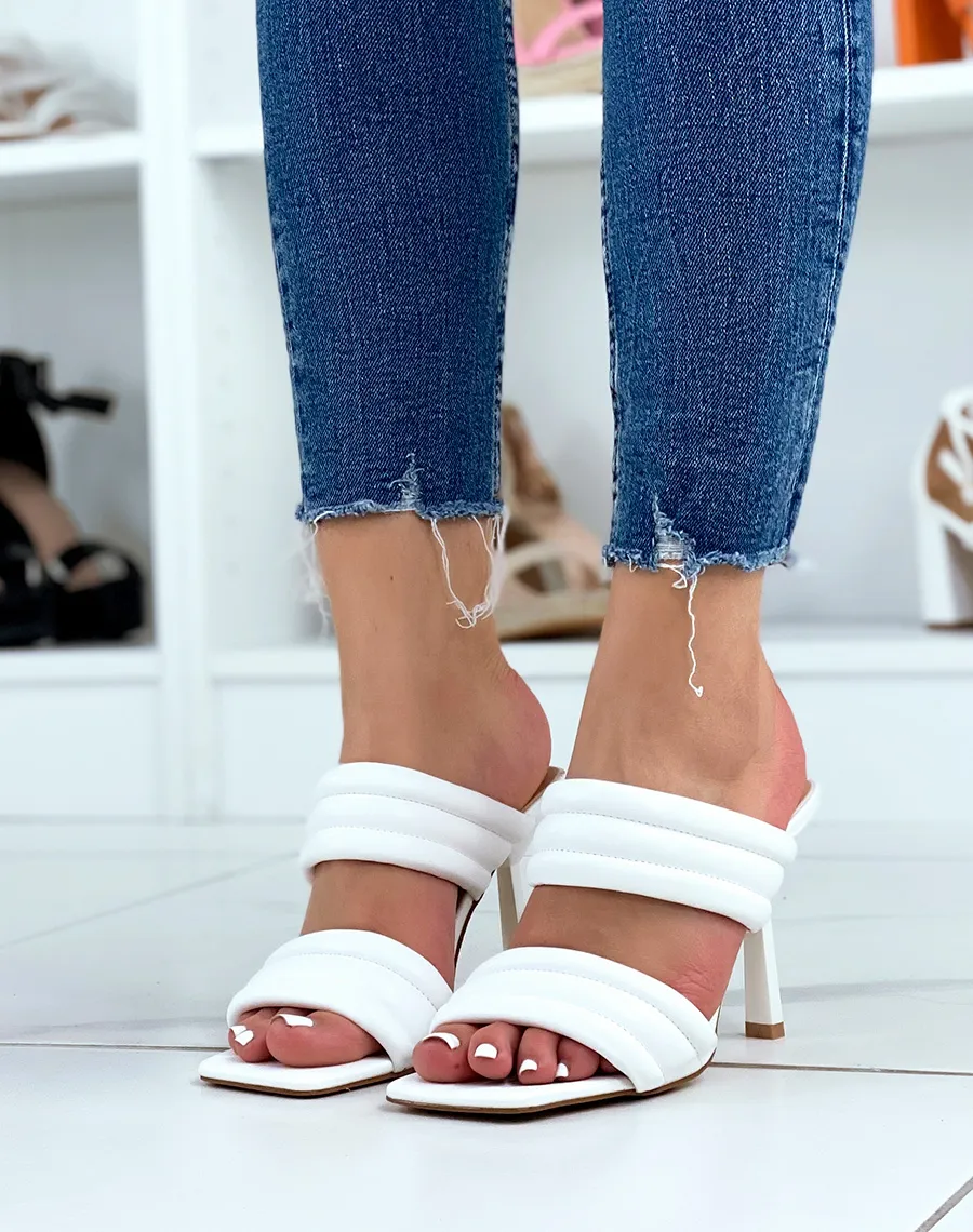 White sandals with thick straps and stiletto heel.