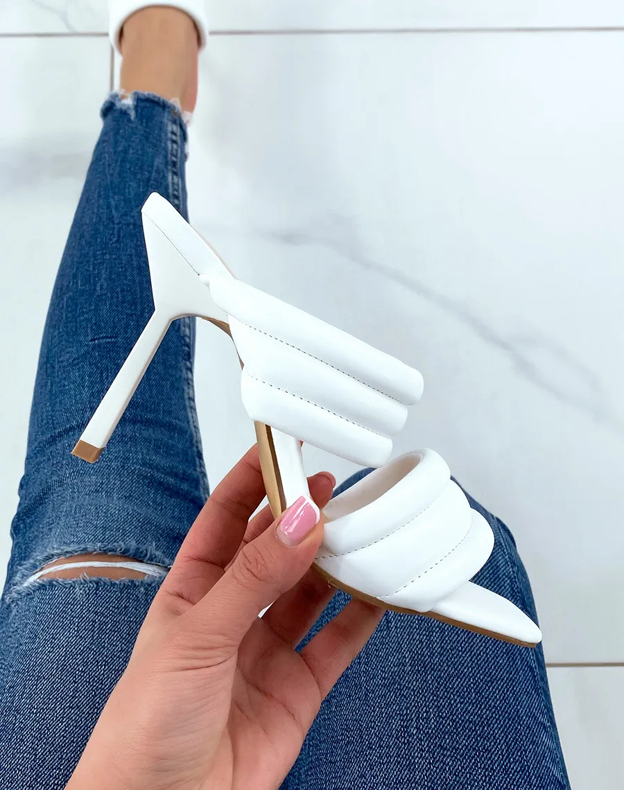 White sandals with thick straps and stiletto heel.