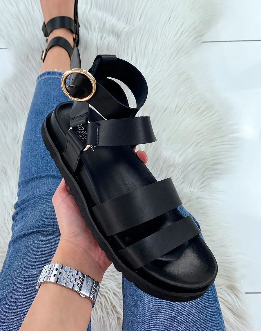 Black sandals with multiple straps and gold buckles.