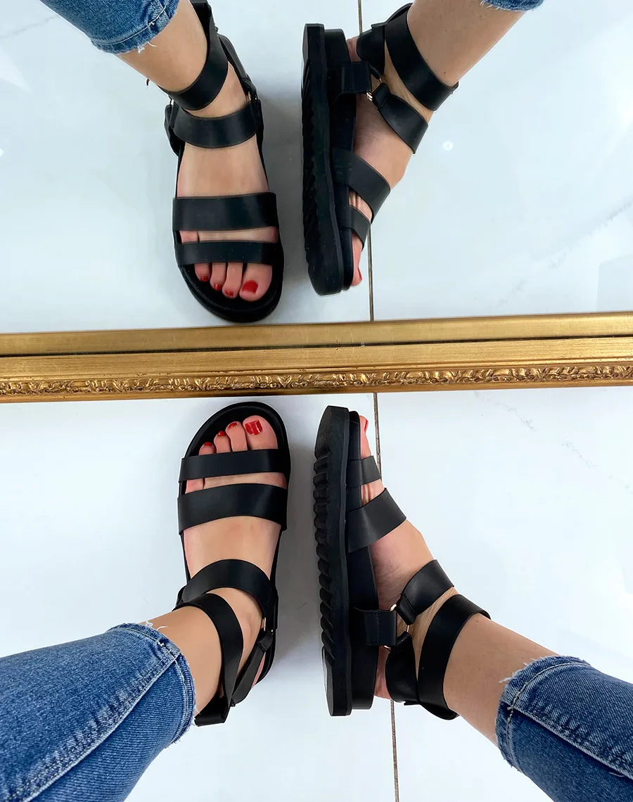 Black sandals with multiple straps and gold buckles.